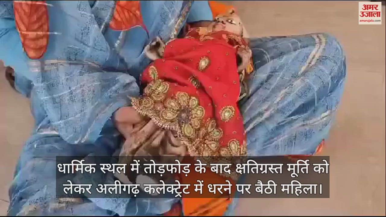 VIDEO : धार्मिक स्थल में तोड़फोड़ के बाद क्षतिग्रस्त मूर्ति को लेकर अलीगढ़ कलेक्ट्रेट में धरने पर बैठी महिला