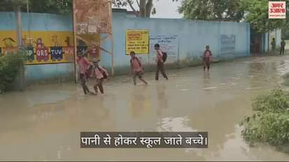 VIDEO : Road to school filled with rain water, school children reach school through water