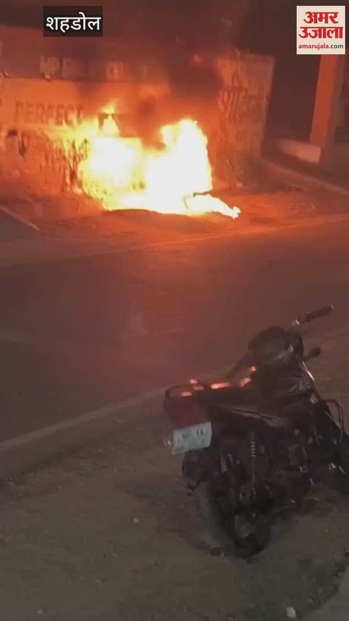 A crazy young man set a moving bike on fire, kept standing and watching the bike burn