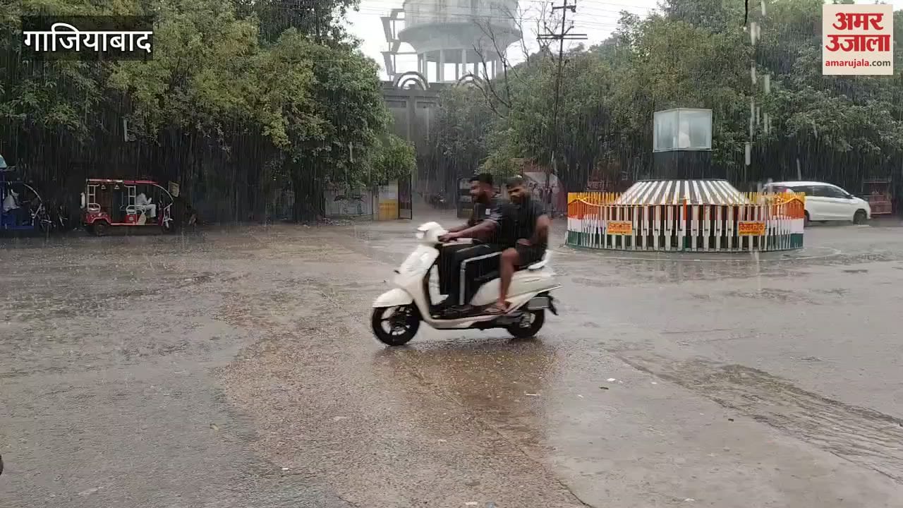 Vehicles passing on road in Vasundhara during rain