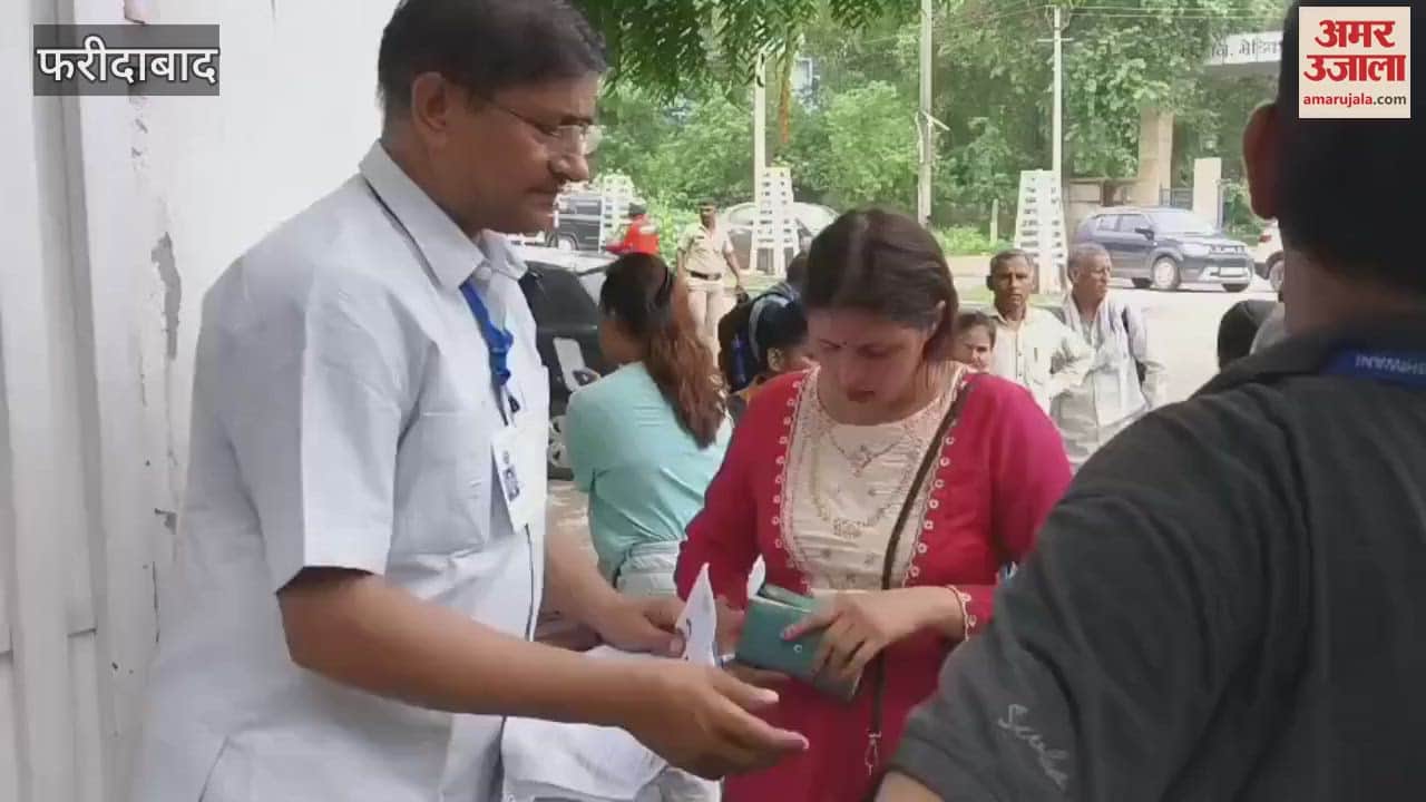 Security personnel checking the admit cards of candidates appearing for HTET exam