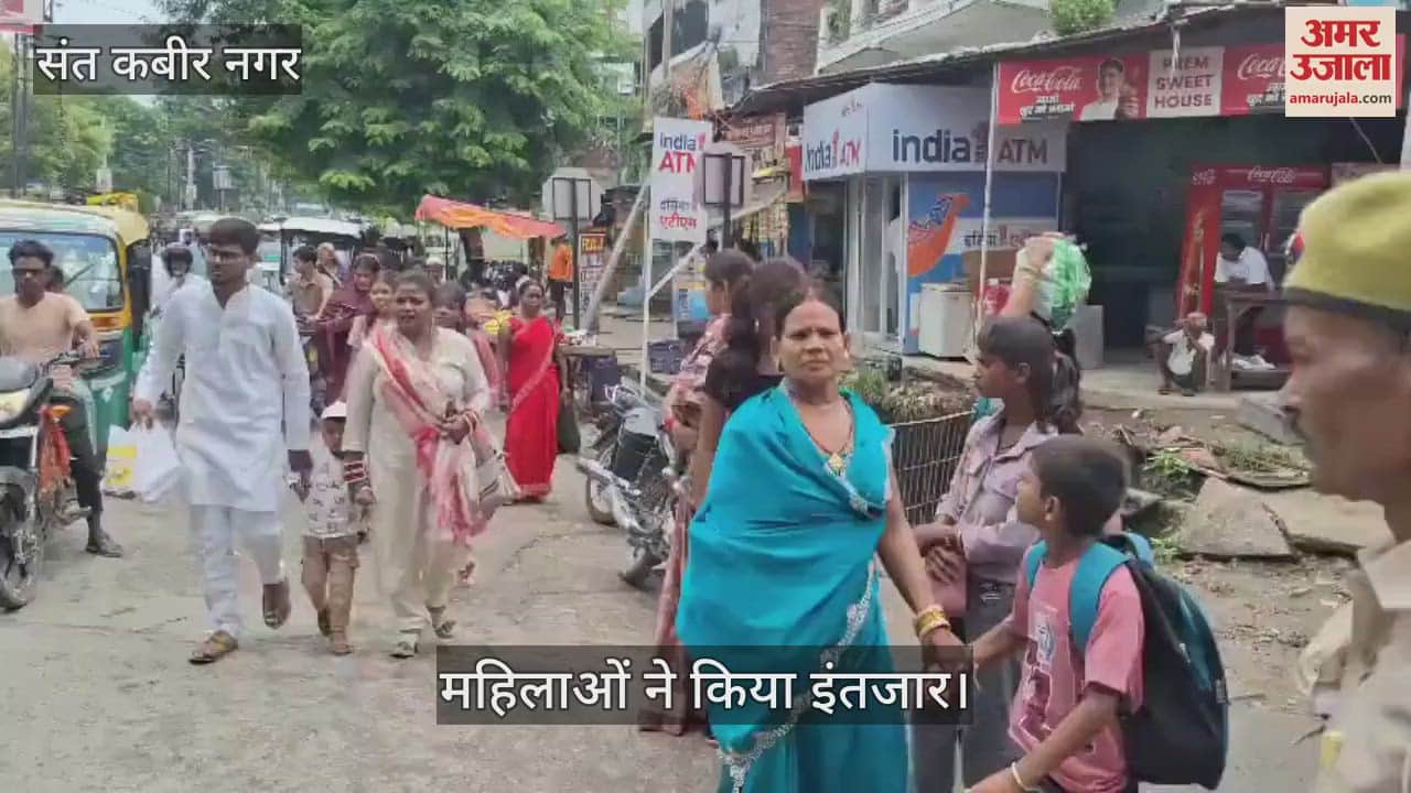 Women were standing waiting for buses, there was a crowd at the bus stand