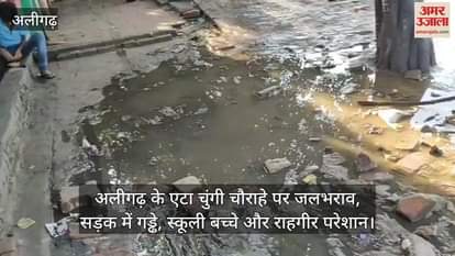 अलीगढ़ के एटा चुंगी चौराहे पर जलभराव, सड़क में गड्ढे, स्कूली बच्चे और राहगीर परेशान