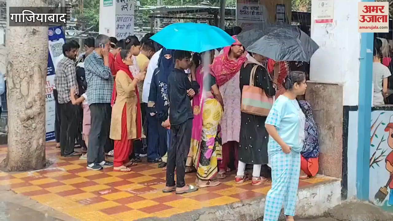 Patients standing registration counter MMG Hospital with umbrella in rain