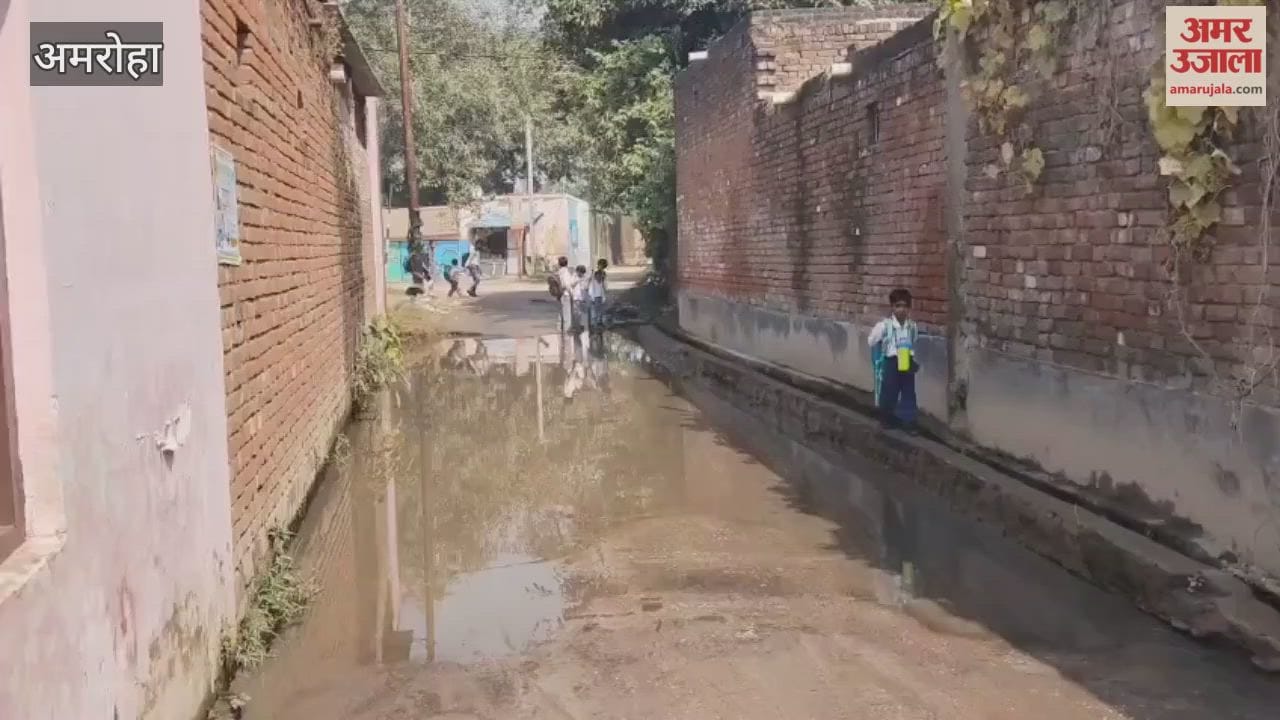 Students passing through the drain wall due to water filled on the road.