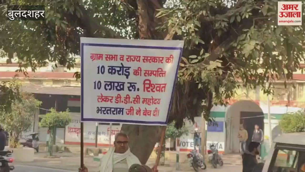 A grandfather and grandson arrived at the collectorate in Bulandshahr holding a banner against bribery