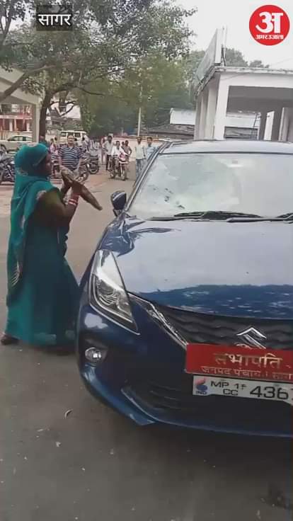 Sagar News: An angry woman smashed the car of a district member.