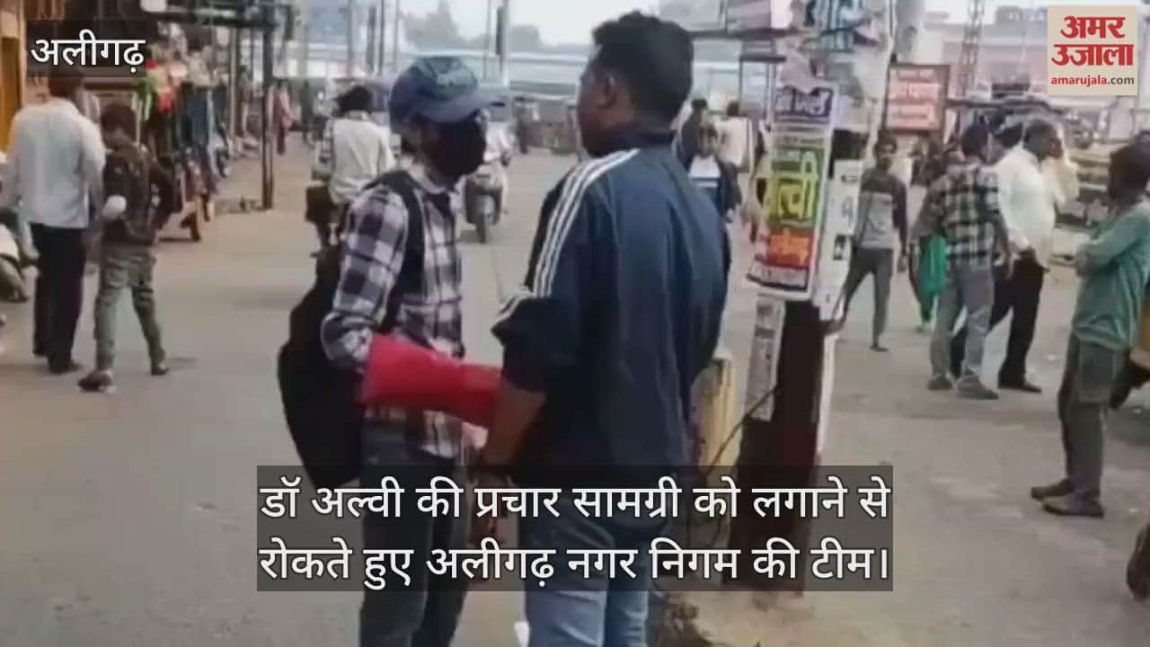 डॉ अल्वी की प्रचार सामग्री को लगाने से रोकते हुए अलीगढ़ नगर निगम की टीम