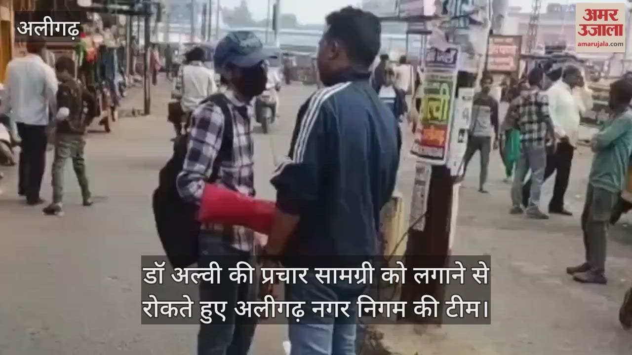 डॉ अल्वी की प्रचार सामग्री को लगाने से रोकते हुए अलीगढ़ नगर निगम की टीम