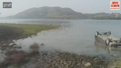 Jhansi: A speeding car lost control and overturned in the waterlogged dam in Mauranipur.