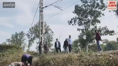 मास्ट पर वजन बांधने में लगे रेलवे के कर्मचारी