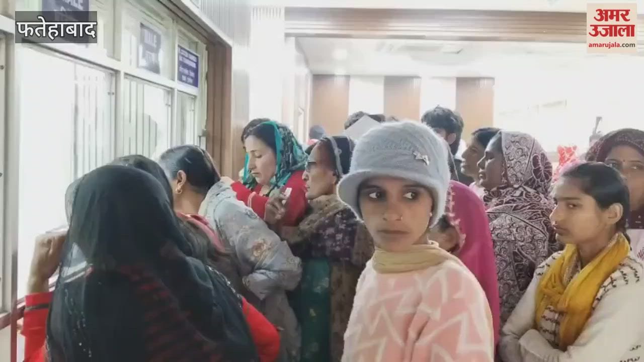 In Fatehabad, two employees are on duty at the OPD registration counter, and patients are lining up for registration slips.