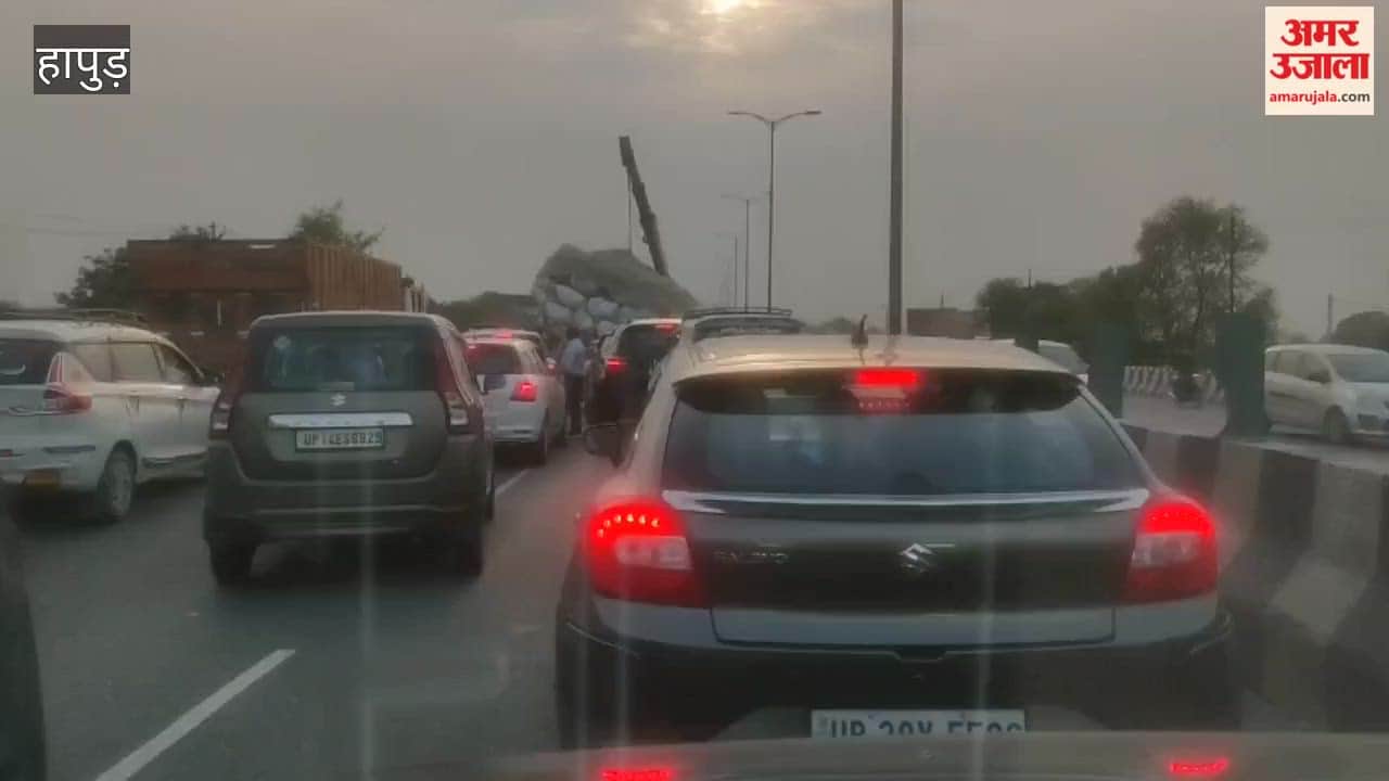 Overloaded tractor trolley filled with straw overturned causing a long traffic jam on highway