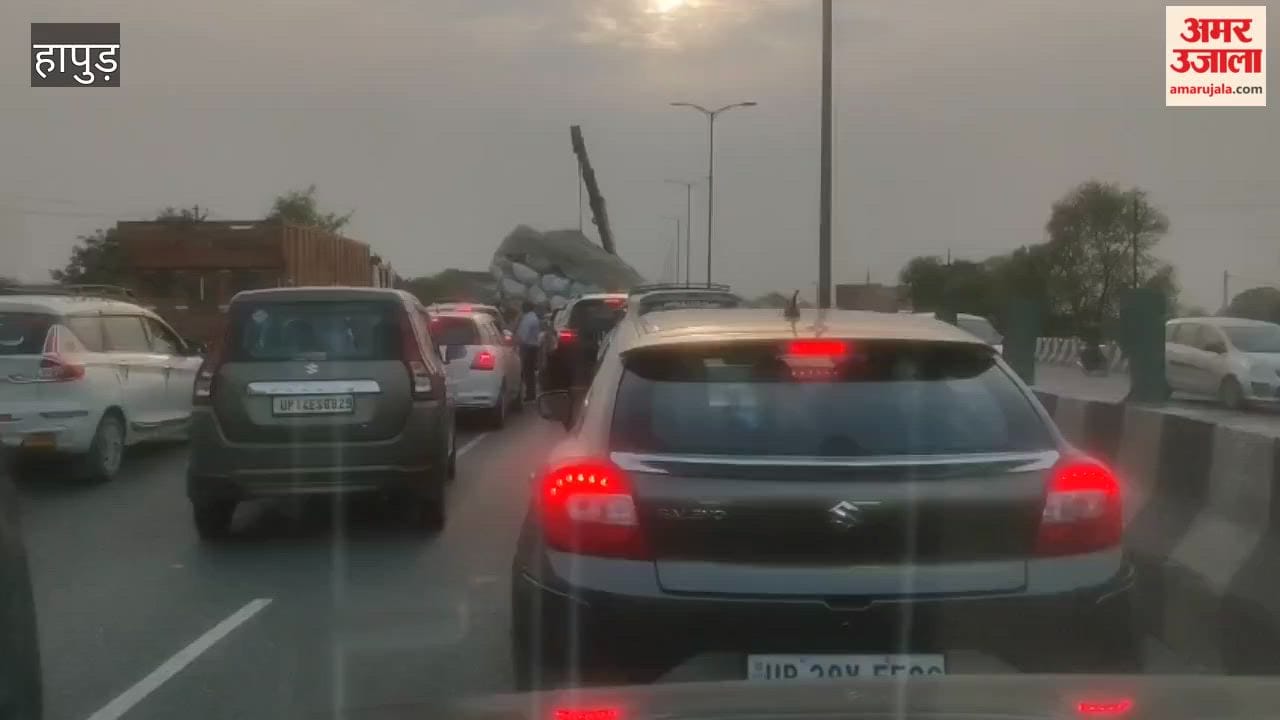 Overloaded tractor trolley filled with straw overturned causing a long traffic jam on highway