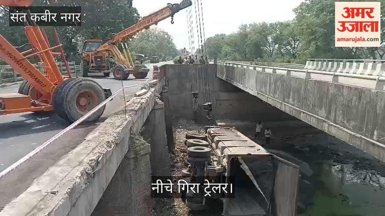 Trailer plunges off bridge after tyre burst and railing breaks—lifted by crane.