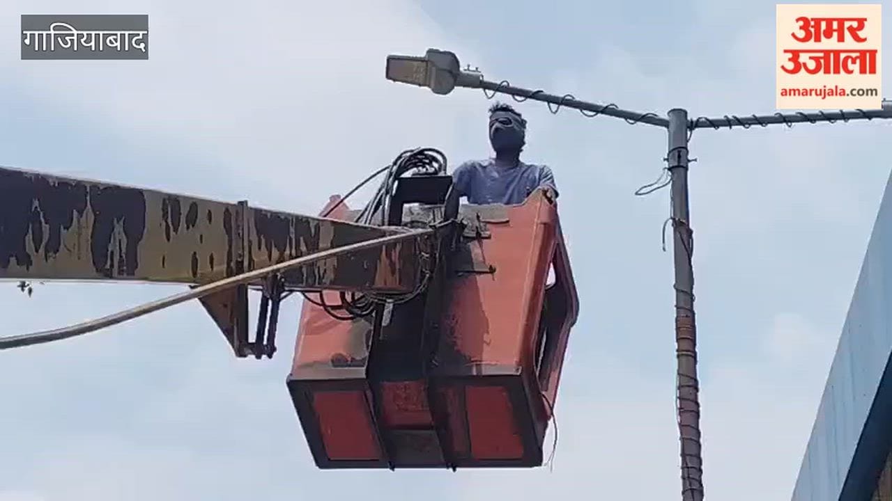 Workers repairing streetlights on flyover near Sahibabad village ahead of Kanwar Yatra