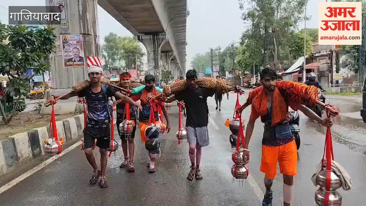 Kanwariyas passing along the Delhi-Meerut highway while getting drenched in the rain in Ghaziabad.