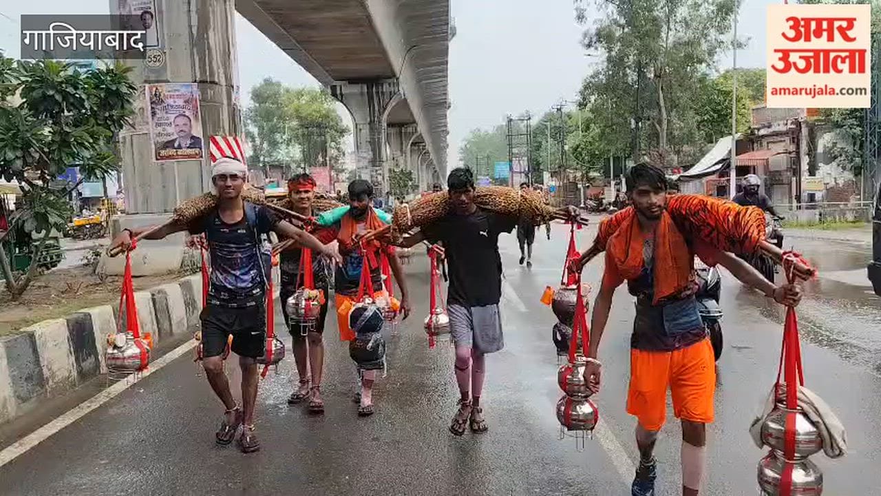 Kanwariyas passing along the Delhi-Meerut highway while getting drenched in the rain in Ghaziabad.