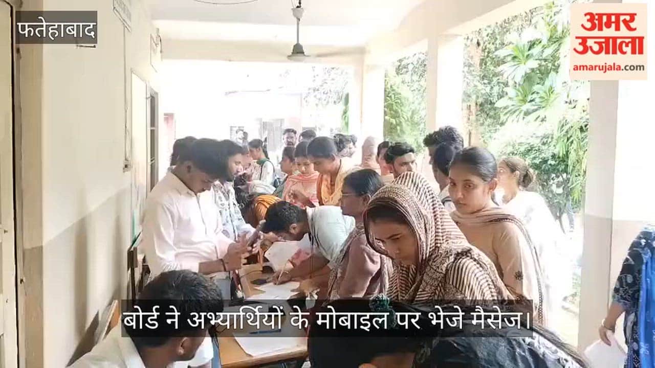 Crowd of candidates gathers in the rain for HTET biometric verification.