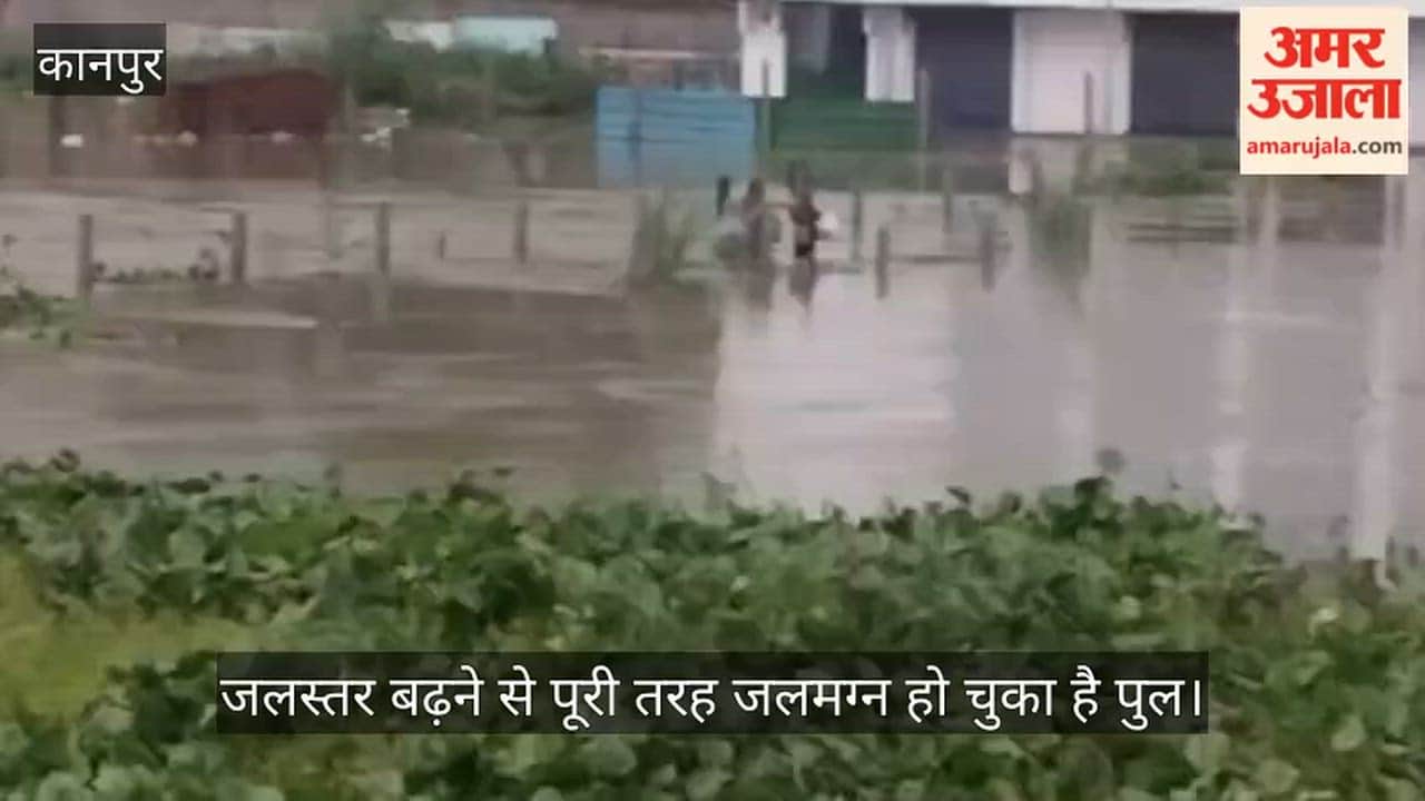 Kanpur Villagers crossing a submerged bridge amidst the overflowing Pandu River