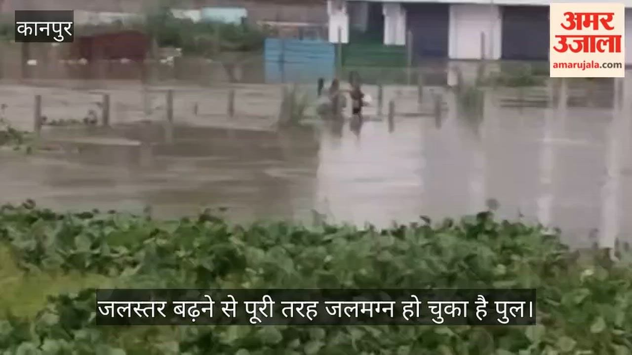 Kanpur Villagers crossing a submerged bridge amidst the overflowing Pandu River