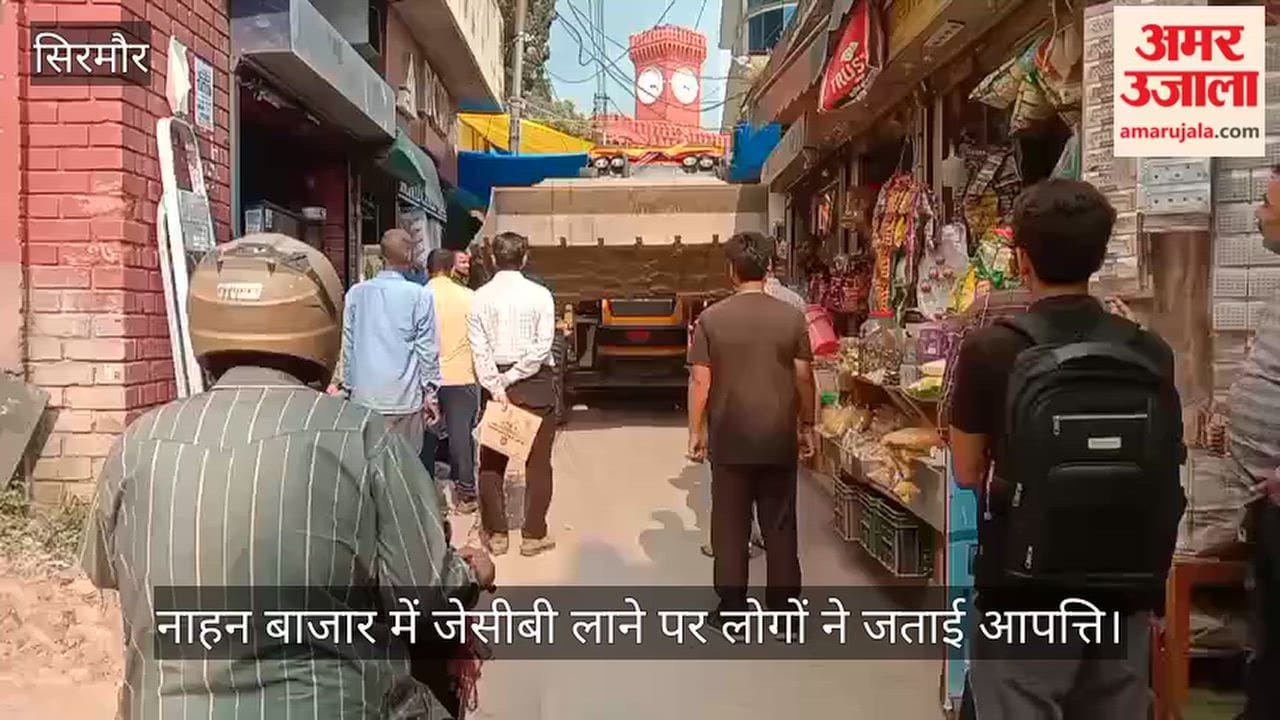 People object to JCB being brought into Nahan market; traffic stalls on narrow road.