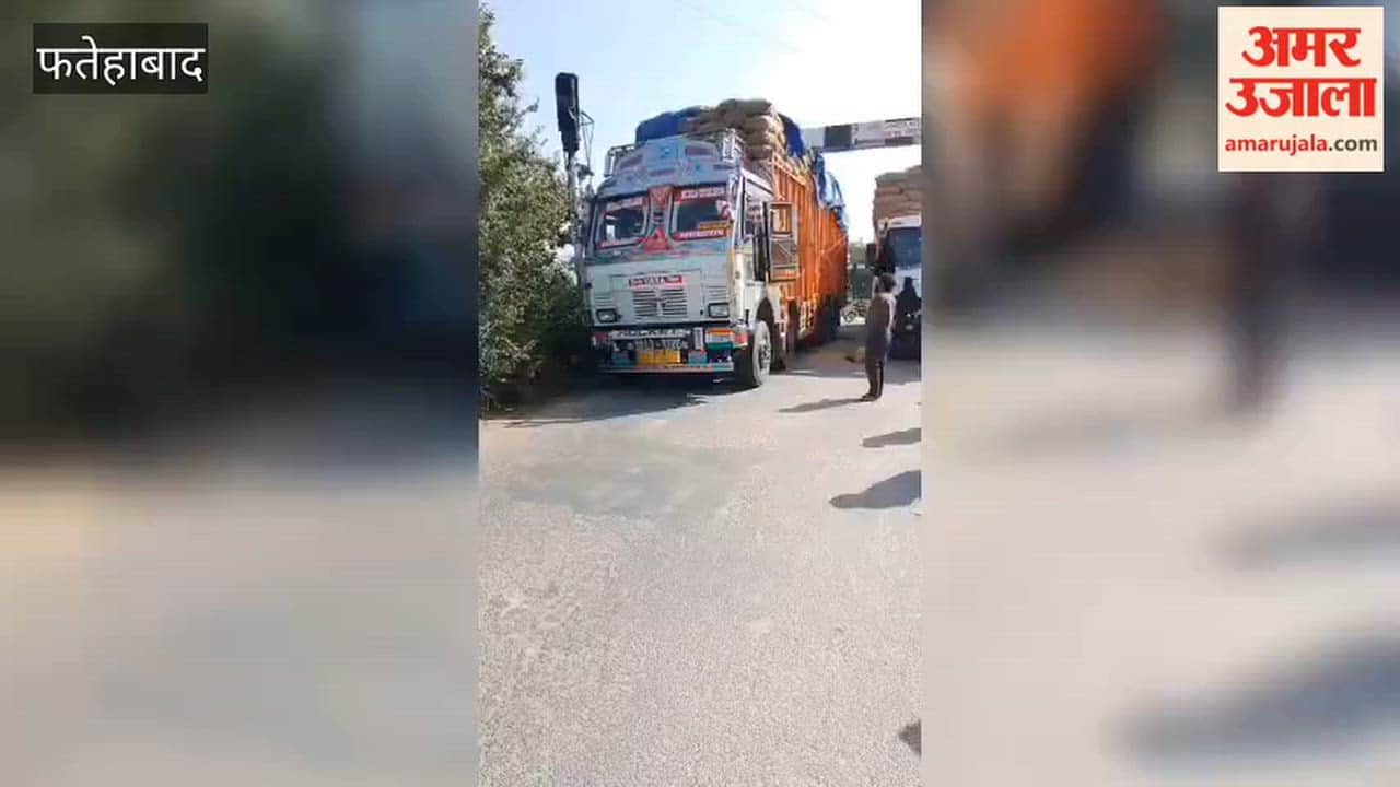Two trucks carrying paddy from UP got stuck at the railway crossing, causing a massive traffic jam on both sides of Damkora Road; motorists are facing inconvenience.