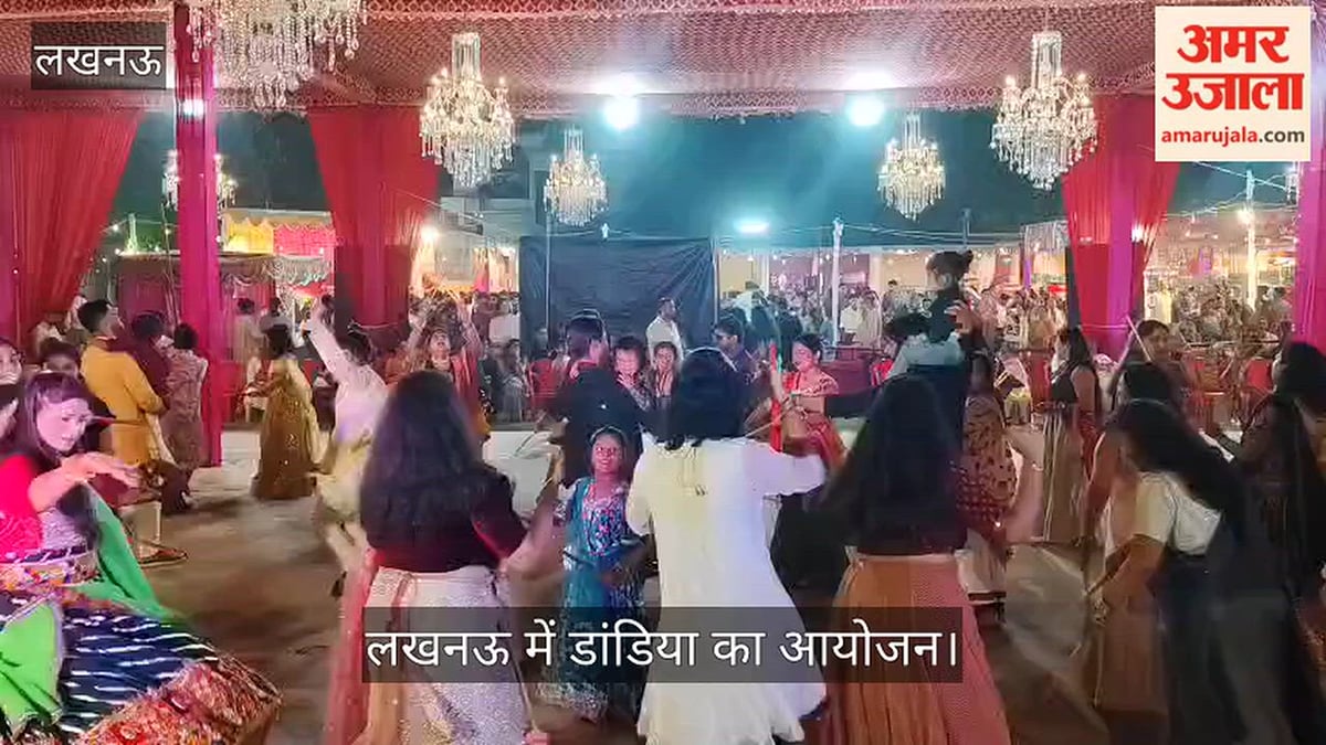 लखनऊ: गोमती नगर में सार्वजनिन पूजा समिति द्वारा आयोजित दुर्गा पूजा पंडाल में डांडिया करते लोग