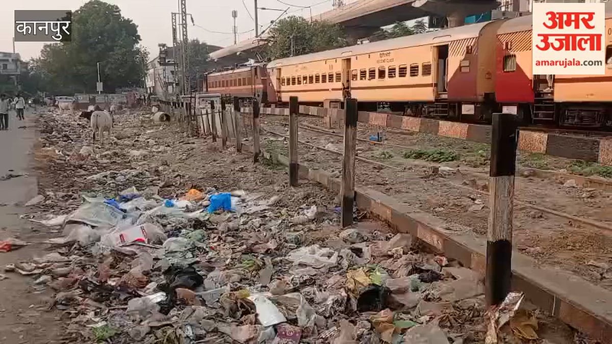कानपुर: रेलवे ट्रैक किनारे गंदगी का अंबार के पास से होकर स्टेशन पहुंच रहे यात्री